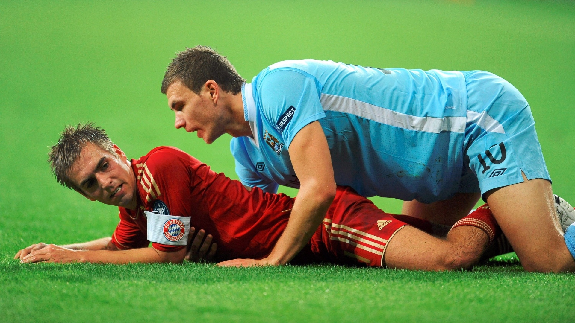 philipp-lahm-do-bayern-de-munique-e-edin-dzeko-do-manchester-city-caem-no-chao-durante-confronto-pe